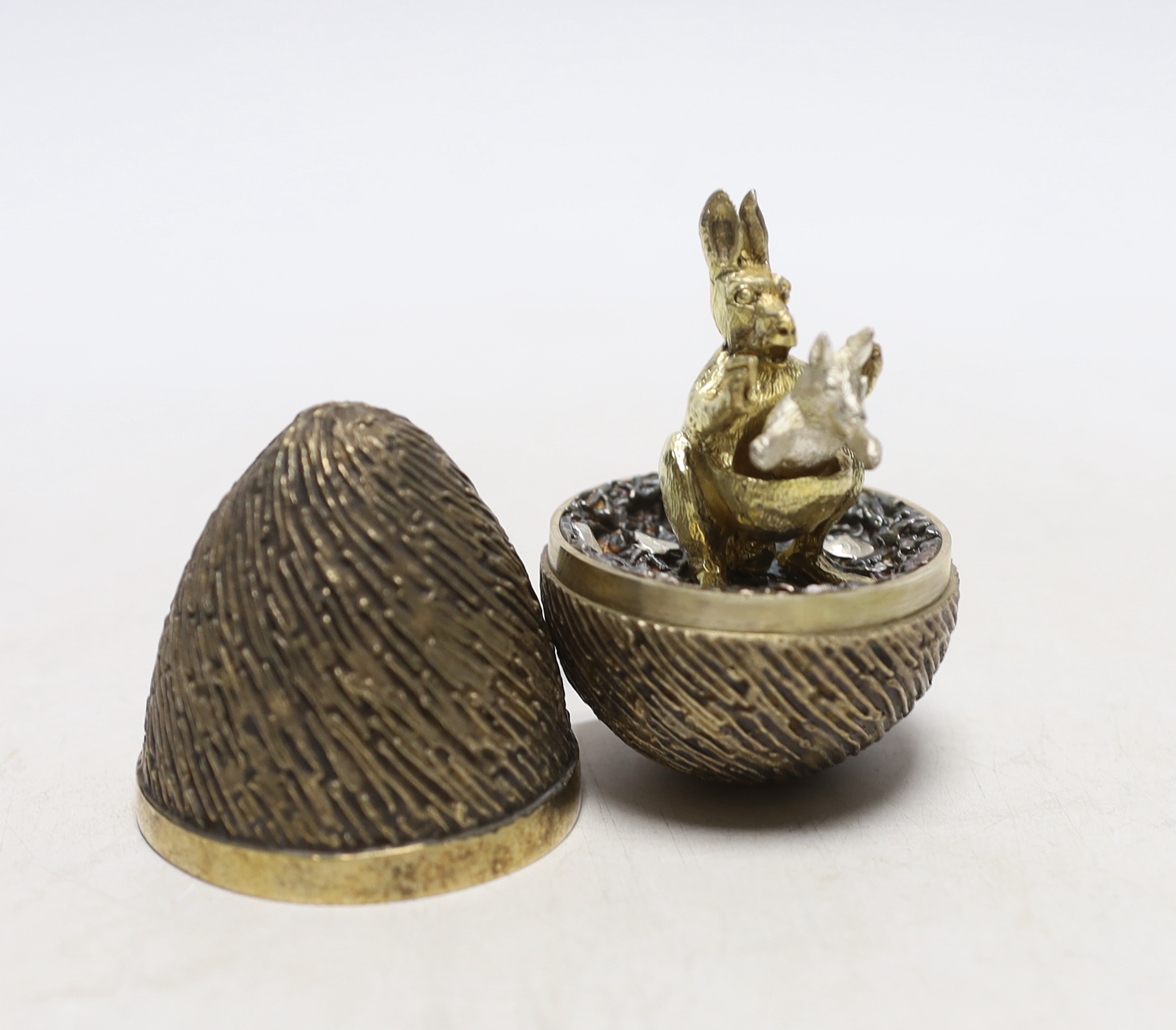 An Elizabeth II silver gilt surprise egg, by Stuart Devlin, London, 1974, numbered 76, opening to reveal a kangaroo with joey, 71mm.